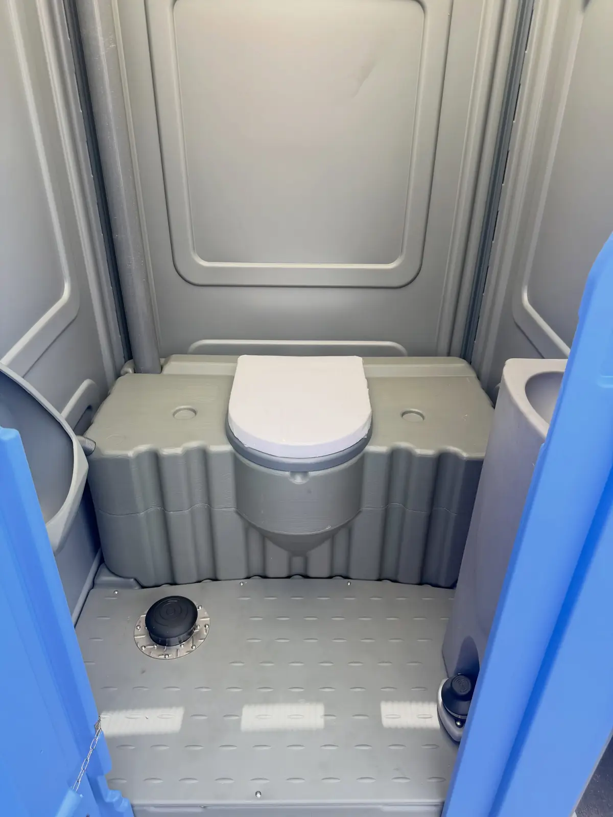 Toilet with foot-pump flush inside a deluxe portable restroom