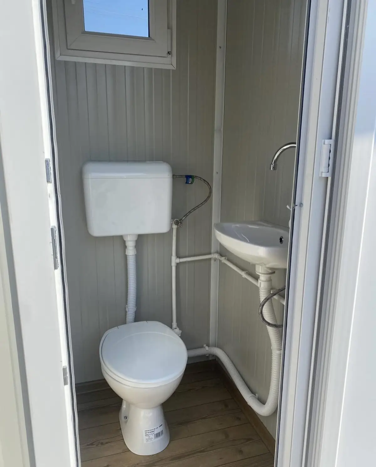 Interior of a deluxe flushing porta potty showing the hand sink and water tank