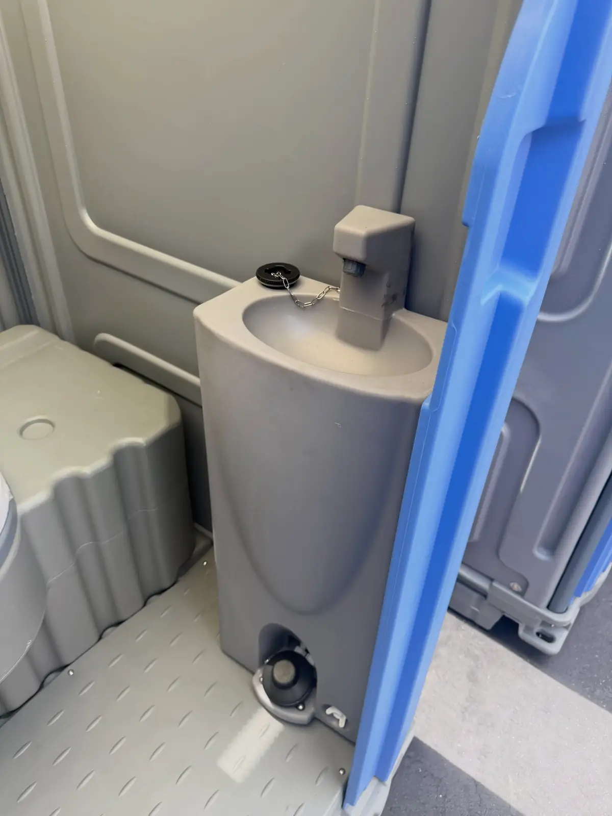 Small hand sink with pump inside a portable restroom