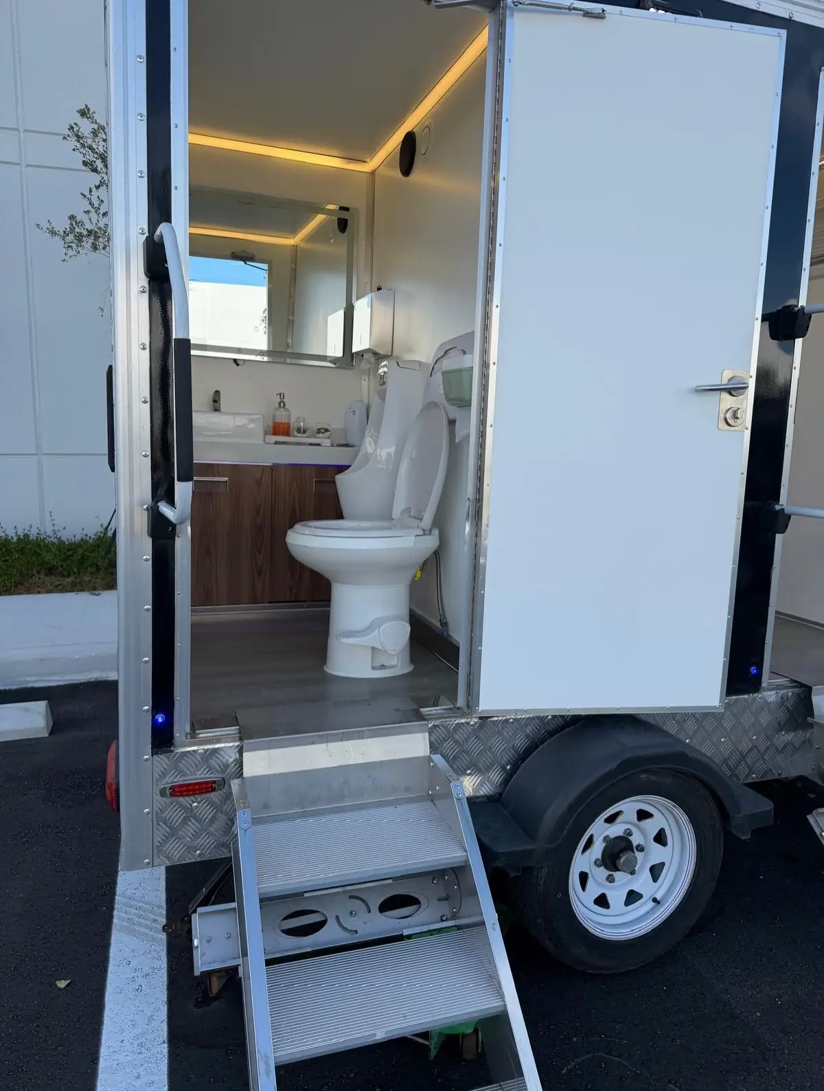Wood vanity, sink and mirror inside a restroom trailer