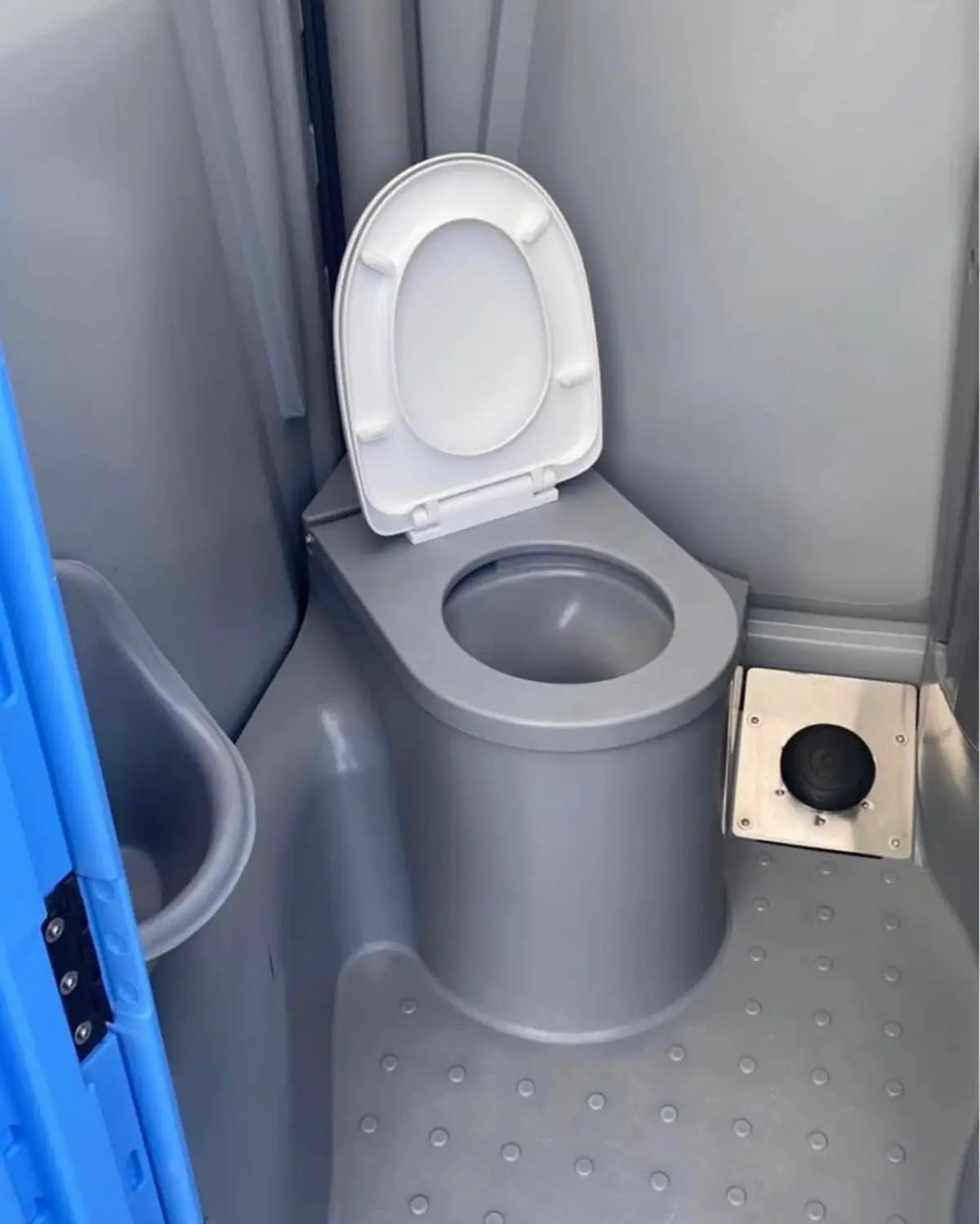 Clean porta potty seat with blue deodorizer visible in the tank